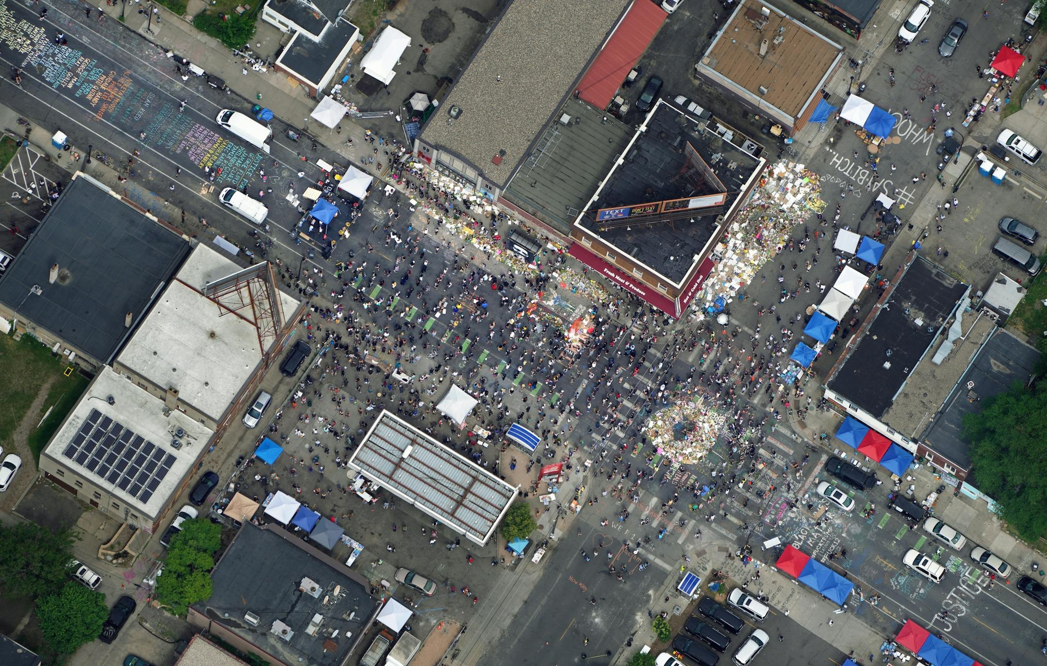 As the private memorial service for George Floyds was taking place across town, a crowd gathered at the corner of Chicago Avenue and 38th Street where Floyd was killed. The sprawling memorial with piles of flowers, art work, pleas for justice, a chalk drawing of Floyd's body with wings and a list of othes who have died at the hands of police. brian.peterson@startribune.com Minneapolis, MN Thursday, June 4, 2020