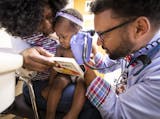 Dr. Nathan Chomilo checks the ears of 15-month-old Tedra Gbelia during her well-child visit as her mother Lorpu Cyrus distracts her with the book she just received. ] LEILA NAVIDI &#xef; leila.navidi@startribune.com BACKGROUND INFORMATION: Dr. Nathan Chomilo sees 15-month-old Tedra Gbelia for a well-child visit with her mother Lorpu Cyrus at Park Nicollet Clinic in Brooklyn Center on Friday, July 13, 2018.