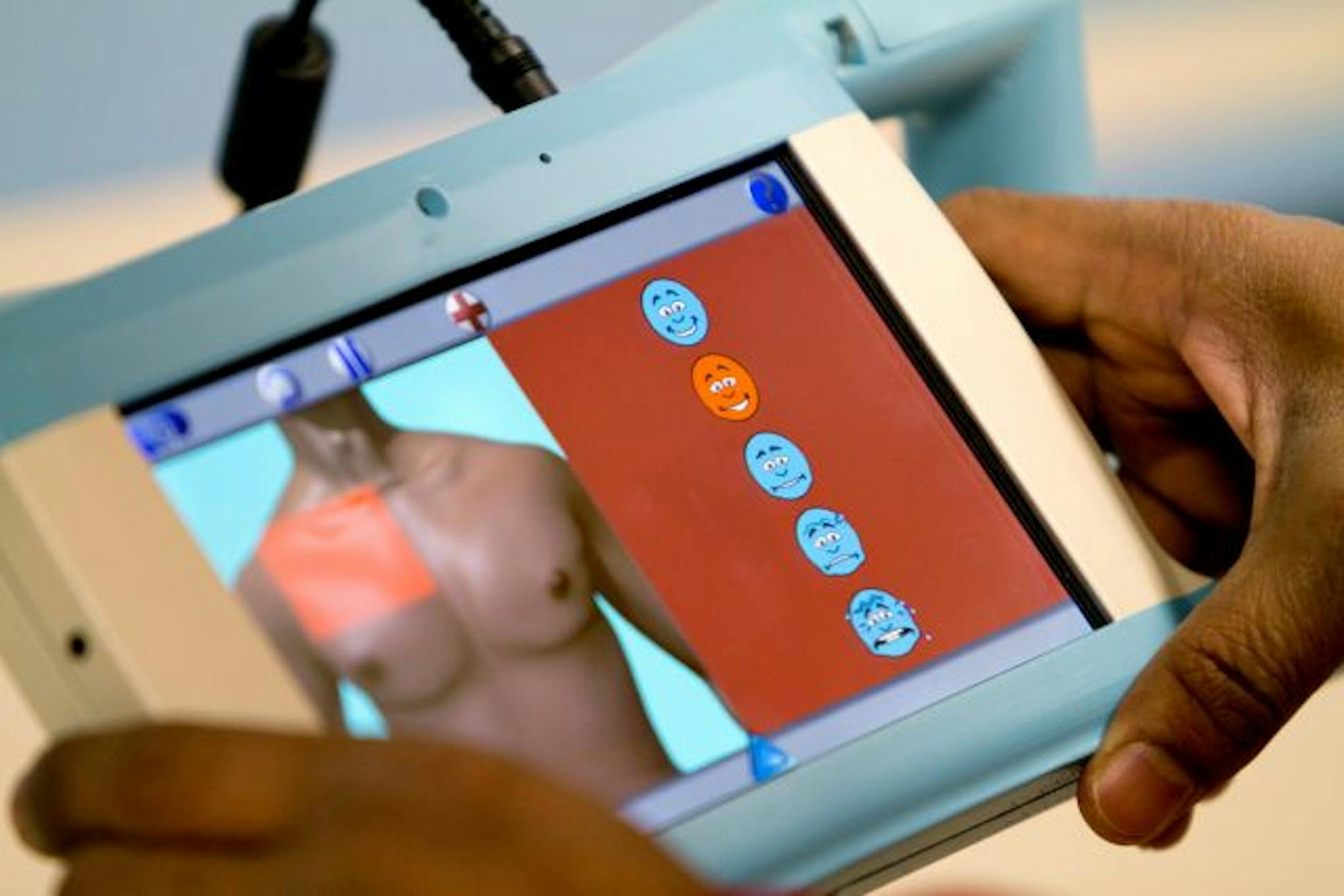 02.17.11 Abhi Mahule, Lead Software Programmer at GeaCom, Inc., demonstrates how a patient can show how a body part is feeling on the Phrazer, at GeaCom, Inc.'s office in Duluth, Minn., on February 17, 2011. The Phrazer helps caregivers and doctors communicate with patients that speak another language to determine what kind of pain they are experiencing, where it is, and if the patient has allergies. Mahule lives in Duluth. Assignment ID 20016612A