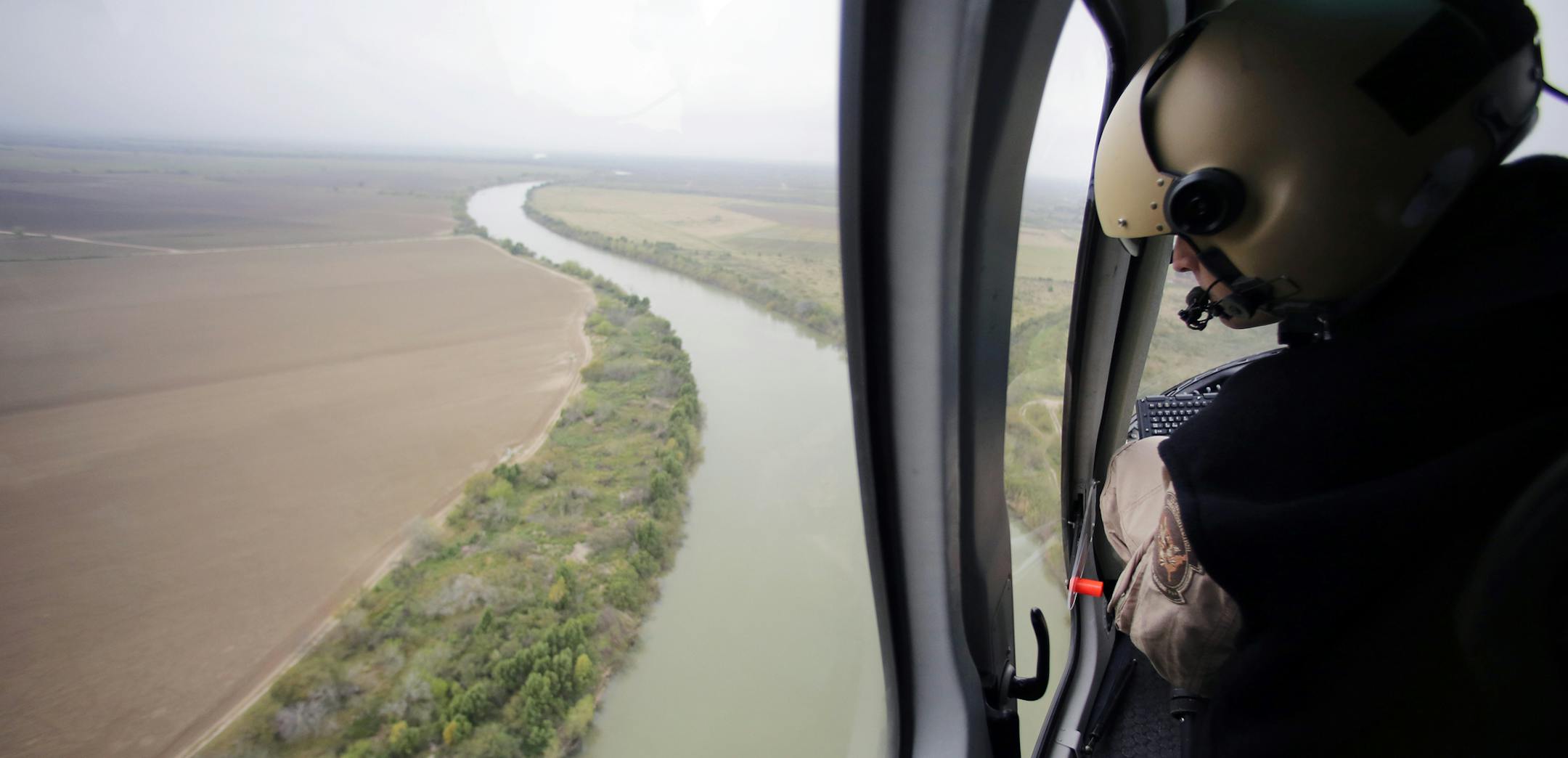 FILE - In this Tuesday, Feb. 24, 2015, aerial file photo, a U.S. Customs and Border Protection Air and Marine agent looks out along the Rio Grande on the Texas-Mexico border in Rio Grande City, Texas. U.S. Homeland Security Secretary Kirstjen Nielsen said Wednesday, April 4, 2018, that President Donald Trump and border-state governors are working to ìimmediatelyî deploy the National Guard to the U.S.-Mexico border to fight illegal immigration. (AP Photo/Eric Gay, File)