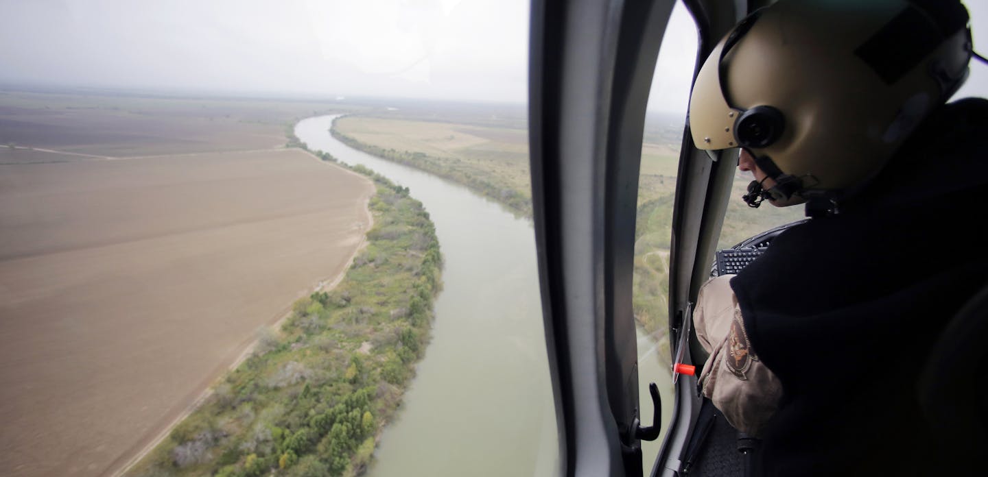 FILE - In this Tuesday, Feb. 24, 2015, aerial file photo, a U.S. Customs and Border Protection Air and Marine agent looks out along the Rio Grande on the Texas-Mexico border in Rio Grande City, Texas. U.S. Homeland Security Secretary Kirstjen Nielsen said Wednesday, April 4, 2018, that President Donald Trump and border-state governors are working to &#xec;immediately&#xee; deploy the National Guard to the U.S.-Mexico border to fight illegal immigration. (AP Photo/Eric Gay, File)