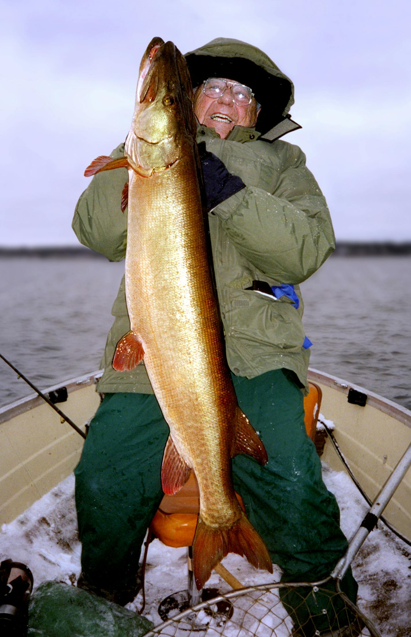 Hugh Becker hefts a 35-pound muskie he caught and released on a cold November day in 2000, likely on a Minnesota lake. Becker died in 2007 at age 89. The earnings from his $3 million estate goes to Muskies Inc. and a Wisconsin rod and gun club.