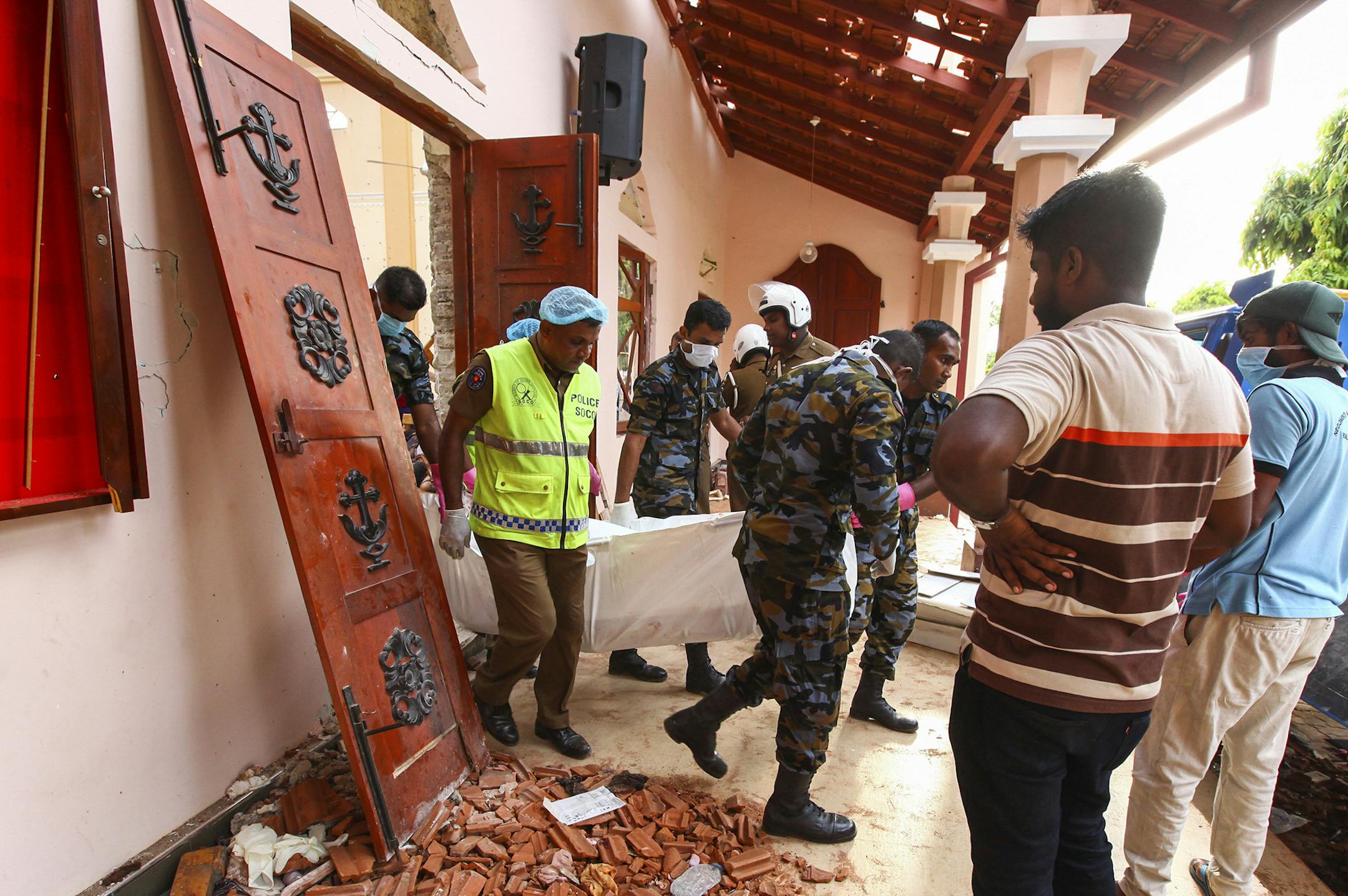 Sri Lankans carry a dead body at St. Sebastian's Church damaged in blast in Negombo, north of Colombo, Sri Lanka, Sunday, April 21, 2019. More than hundred were killed and hundreds more hospitalized with injuries from eight blasts that rocked churches and hotels in and just outside of Sri Lanka's capital on Easter Sunday, officials said, the worst violence to hit the South Asian country since its civil war ended a decade ago. (AP Photo/Chamila Karunarathne) ORG XMIT: COL105