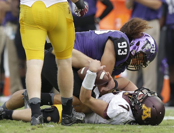Minnesota quarterback Mitch Leidner (7) takes a hard hit from TCU defensive end Mike Tuaua (93) during the second half of an NCAA college football gam