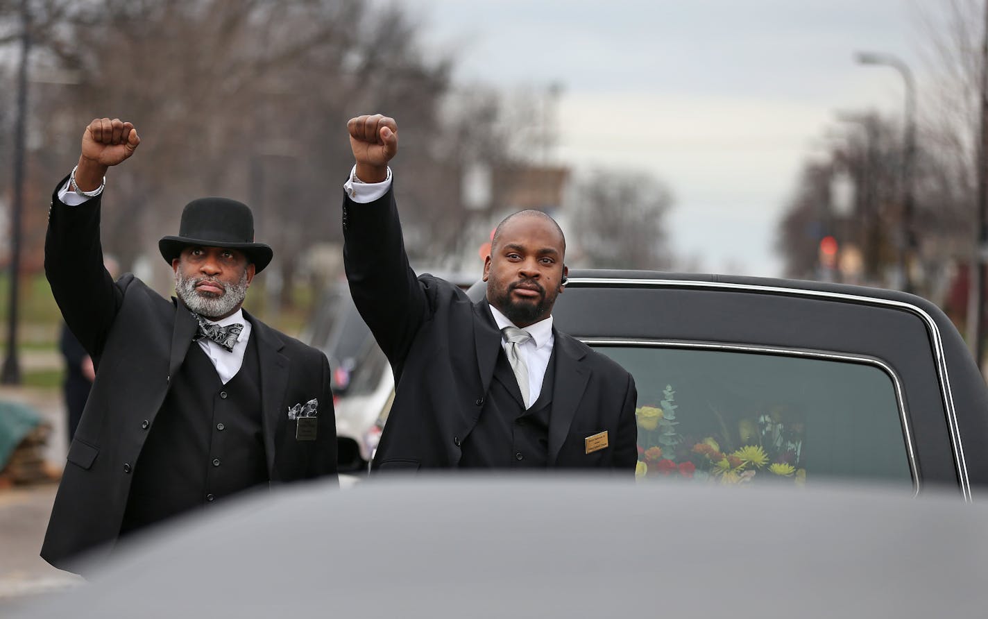 Employees of Estes Funeral Chapel raised their fists to show support for Jamar Clark's family in front of the Fourth Precinct police station November 25, 2015, in Minneapolis.