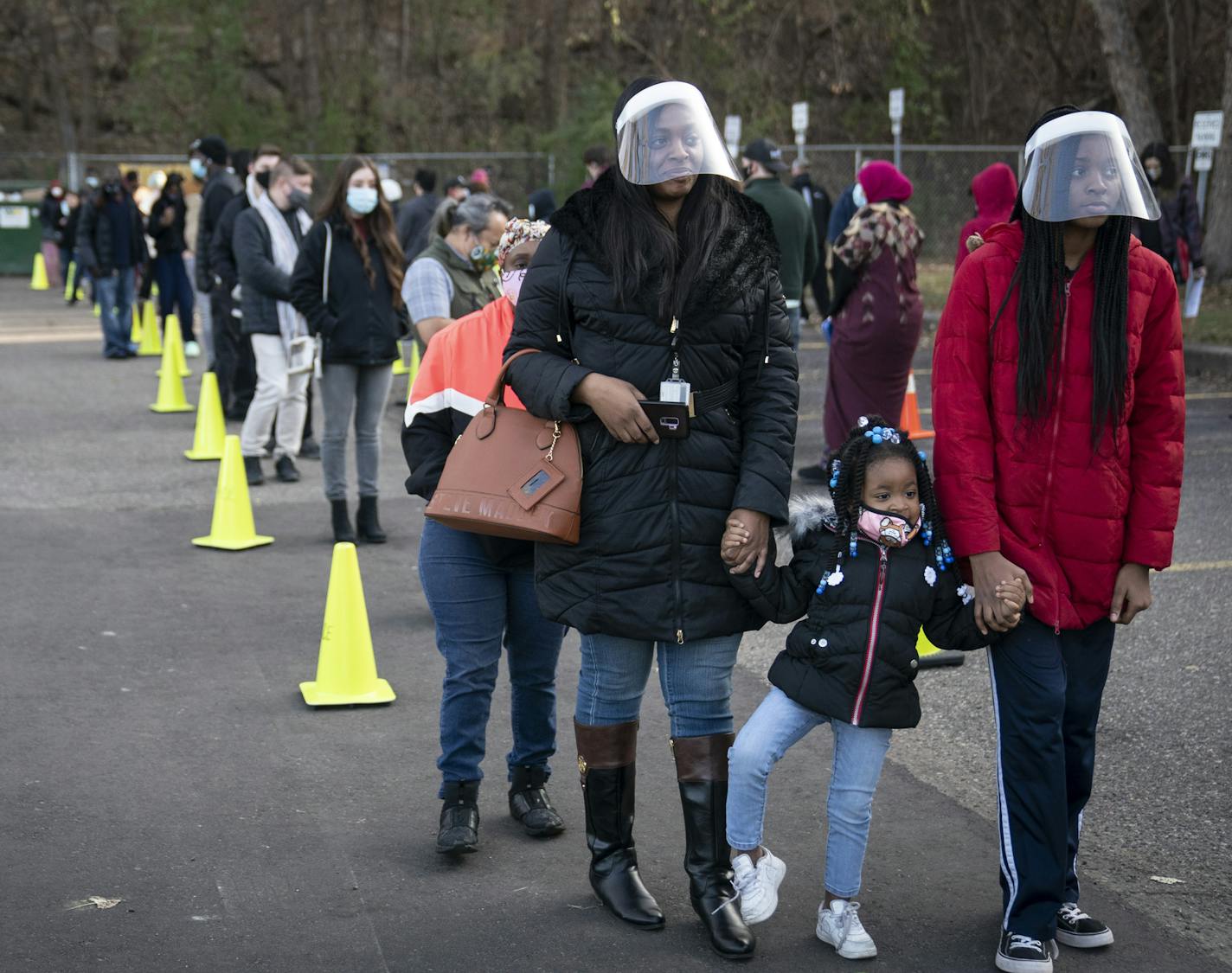 Natasha DaVis and her daughters Natavia DaVis and Natasia DaVis waited in a long line at the Ramsey County Elections office in St. Paul on Monday, Nov. 2, where some people waited up to two hours to vote one day before Election Day.