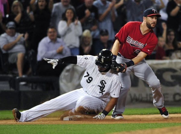The White Sox's Jose Abreu (79) slid safely into third base as Twins third baseman Trevor Plouffe made a late tag during the eighth inning.