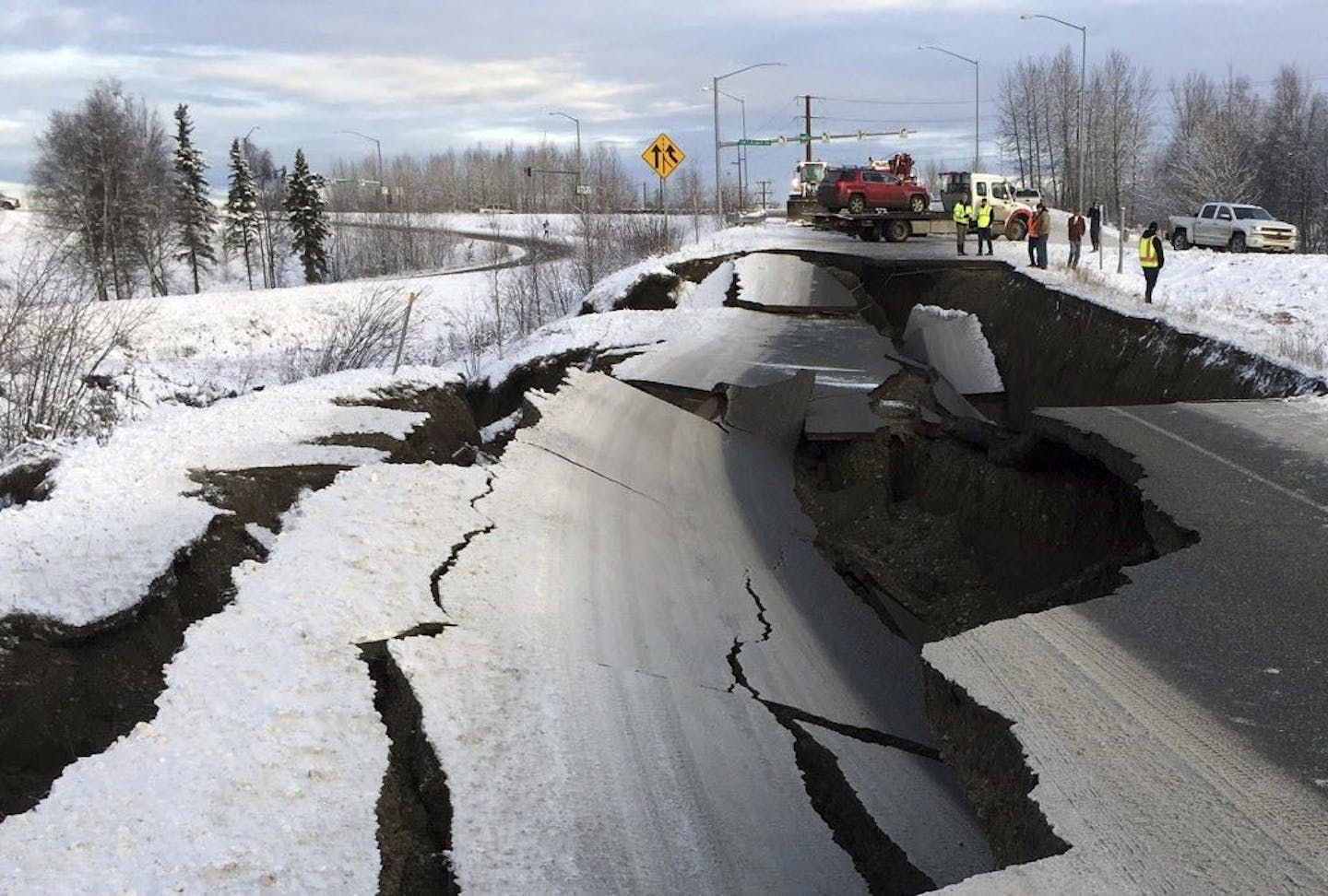 A tow truck holds a car that was pulled from on an off-ramp that collapsed during a morning earthquake on Friday, Nov. 30, 2018, in Anchorage, Alaska. The driver was not injured attempting to exit Minnesota Drive at International Airport Road. Back-to-back earthquakes measuring 7.0 and 5.8 rocked buildings and buckled roads Friday morning in Anchorage, prompting people to run from their offices or seek shelter under office desks, while a tsunami warning had some seeking higher ground.