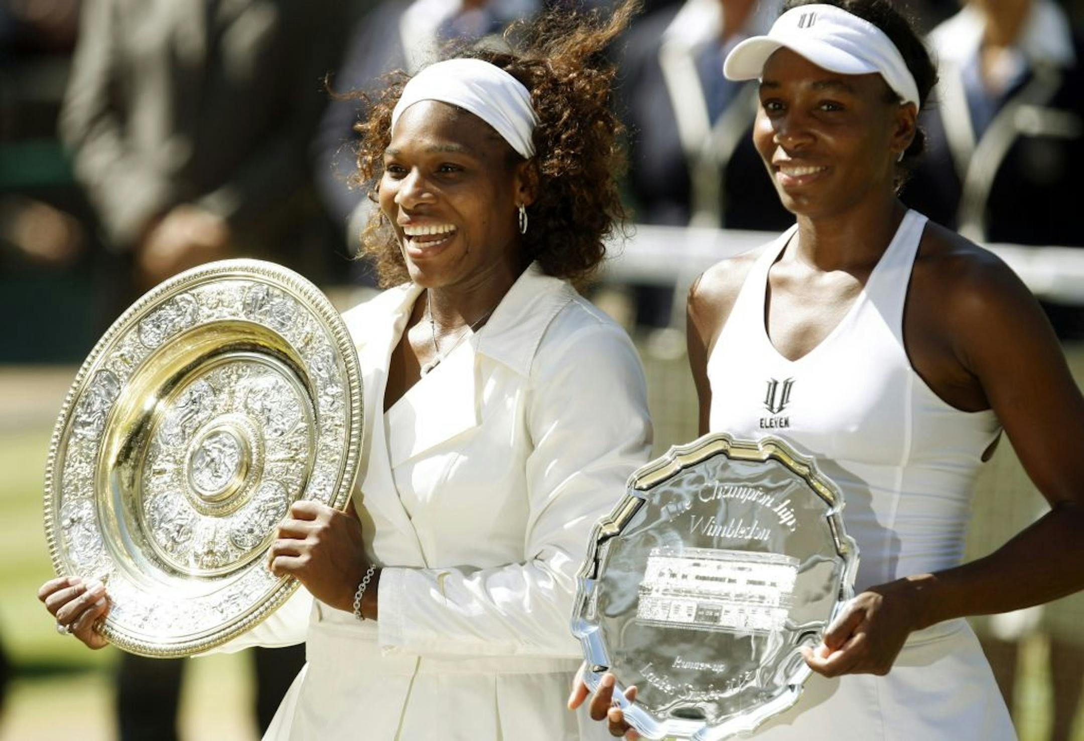 In this July 4, 2009 file photo, Serena Williams left, holds the championship trophy, after defeating her sister Venus, who holds the runners-up trophy, in the women's singles final on Centre Court at Wimbledon.