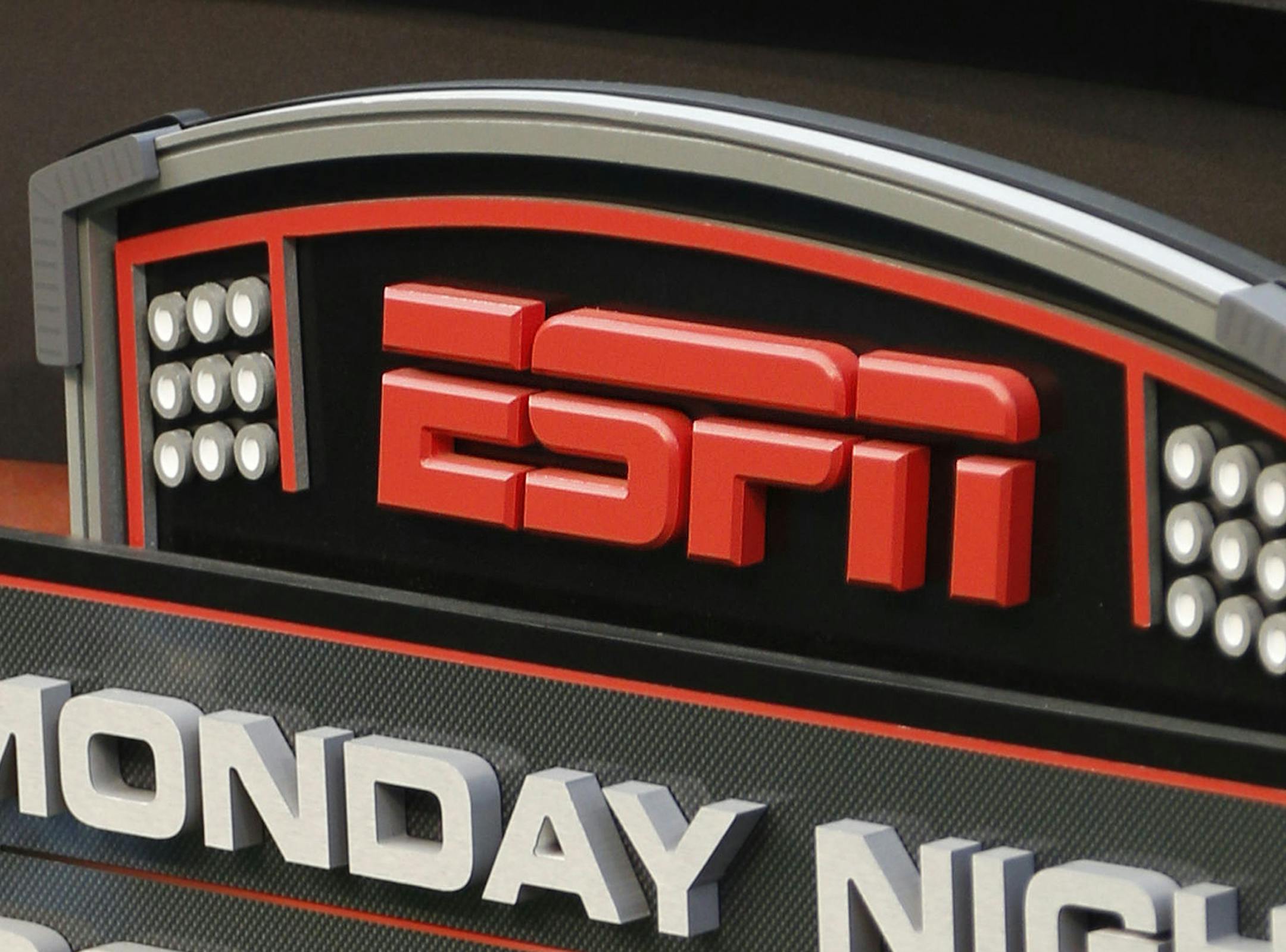 FILE - This Sept. 16, 2013, file photo shows the ESPN logo prior to an NFL football game between the Cincinnati Bengals and the Pittsburgh Steelers, in Cincinnati. ESPN says it is eliminating 150 studio and production employees as the sports broadcasting giant continues to shift its focus to a more digital future. The company says the layoffs, which were announced Wednesday morning, Nov. 29, 2017, in a memo to employees, don't include on-air talent and will have a minimal impact on the network's