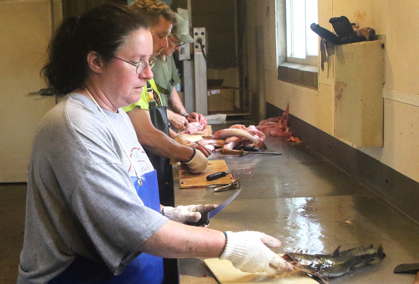 Vickie Jones led the processing line at Mohn Fish Market on a recent day. Her father, Ralph Mohn, is at the end of the line. The family business was founded in 1982.