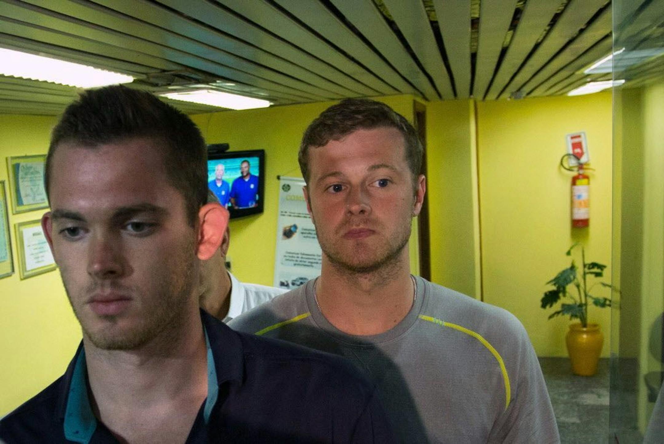 American Olympic swimmers Gunnar Bentz, left, and Jack Conger, center, leave the police station at Rio International airport early Thursday Aug. 18, 2016. The two were taken off their flight from Brazil to the U.S. on Wednesday by local authorities amid an investigation into a reported robbery targeting Ryan Lochte and his teammates. According to their lawyer they will not be allowed to leave Brazil until they provide testimony about the robbery.