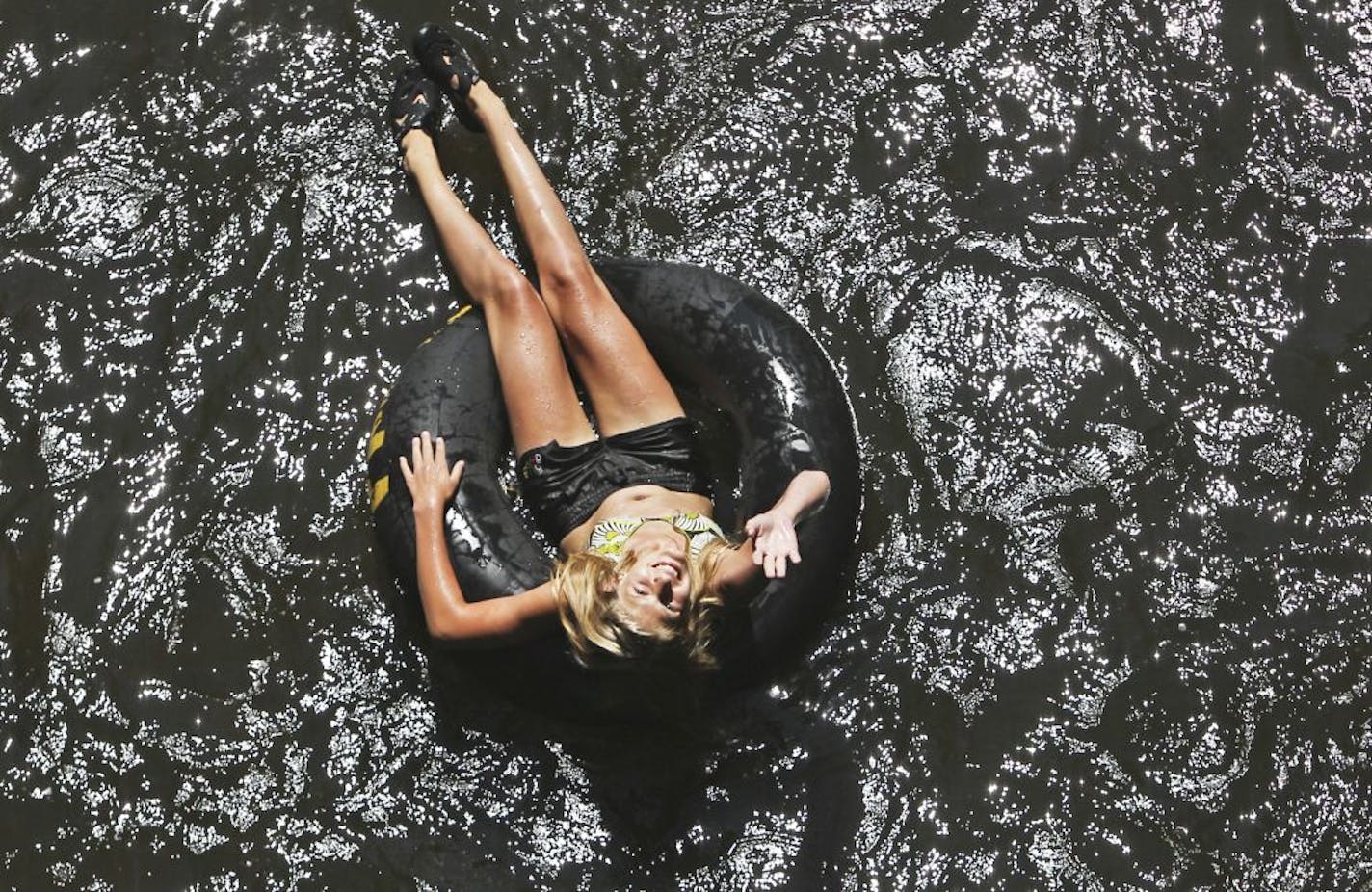 A tuber floated through town, seen from the Main Street bridge, on the Apple River in Somerset, Wednesday, Aug. 3, 2011.