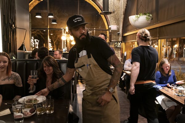Chef and Top Chef contestant Justin Sutherland served plates of food at his restaurant the Handsome Hog in St. Paul.