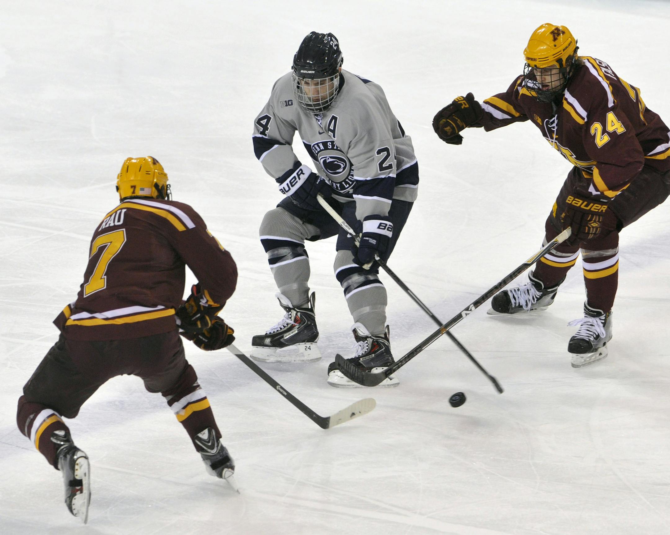 Penn State's Nate Jensen moves the puck between Minnesota's Kyle Rau and Hudson Fasching during an NCAA college hockey game, Friday, Feb. 20, 2015 in State College, Pa.(AP Photo/Centre Daily Times, Christopher Weddle) MANDATORY CREDIT; MAGS OUT