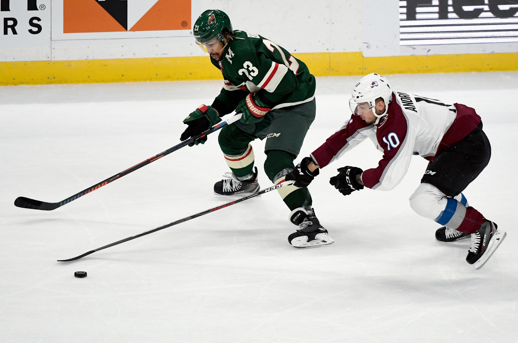 Colorado Avalanche's Sven Andrighetto (10), of Switzerland, takes the puck from Minnesota Wild's J.T. Brown (23) during the first period of an NHL hockey game Saturday, Oct. 27, 2018, in St. Paul, Minn. (AP Photo/Hannah Foslien)