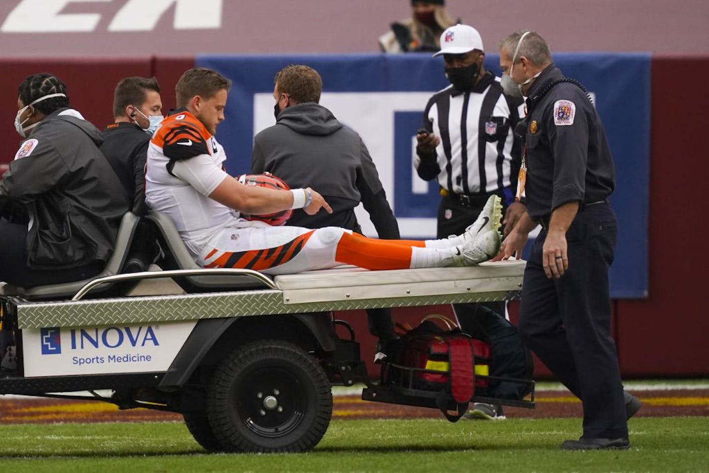 Cincinnati Bengals quarterback Joe Burrow (9) points to his knee as he is charted off the field after an injury in the second half of an NFL football game against the Washington Football Team, Sunday, Nov. 22, 2020, in Landover.