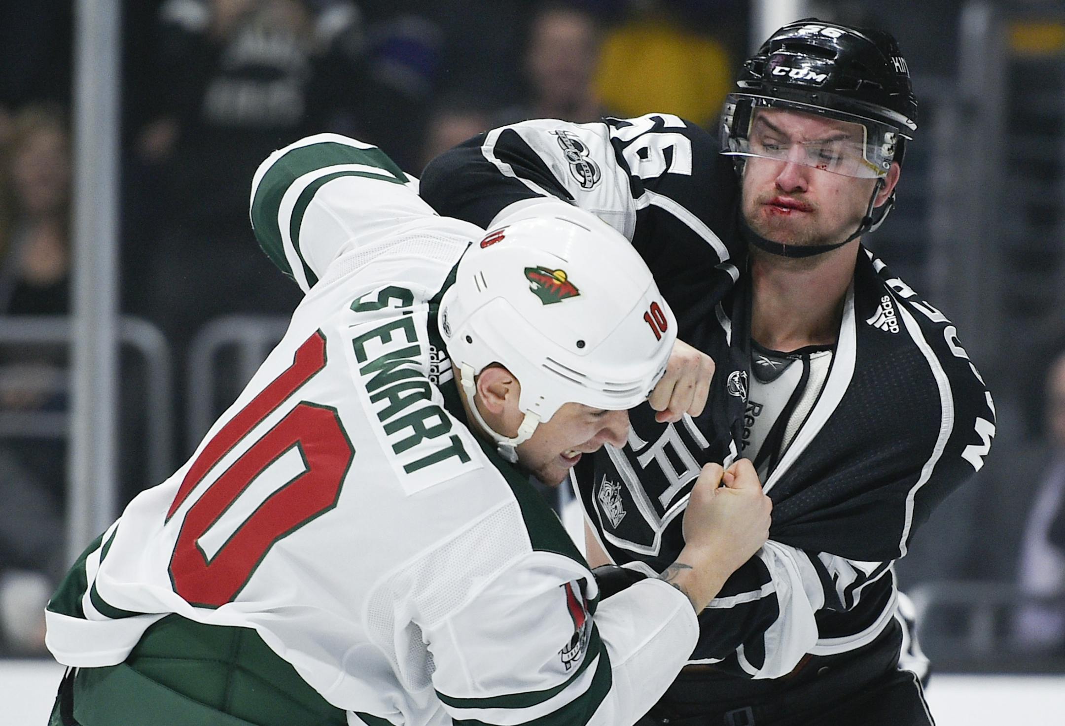 Los Angeles Kings defenseman Kurtis MacDermid, right, fights Minnesota Wild right wing Chris Stewart during the first period of an NHL hockey game in Los Angeles, Tuesday, Dec. 5, 2017.