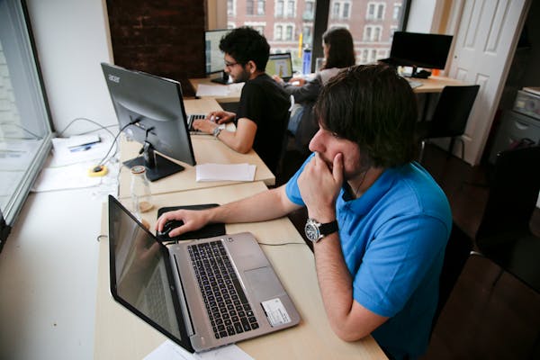 Draftpot co-founder and CEO Joey Levy, foreground, works with co-founder and CTO Joshua Hughes, center, and co-founder and developer Jessica Vandebon 