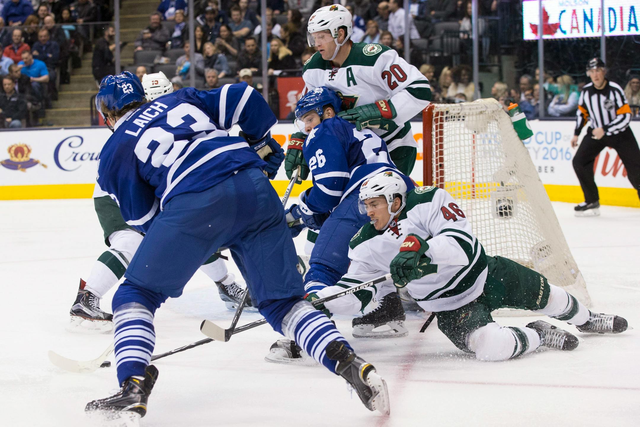 Toronto Maple Leafs' Ben Smith (26) battles for the puck with Minnesota Wild's Jared Spurgeon (46) as Leafs' Brooks Laich (23) and Wild's Ryan Suter (20) look on during second-period NHL hockey game action in Toronto, Thursday, March 3, 2016. (Chris Young/The Canadian Press via AP) MANDATORY CREDIT
