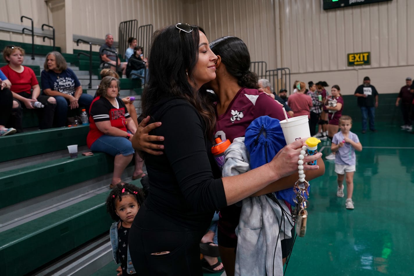 Desirae Holloway, with her 2-year-old daughter, Aliana, hugs her 13-year-old daughter, Ahmya, at Ahmya's volleyball game in Louisville in September. MUST CREDIT: Washington Post photo by Jahi Chikwendiu