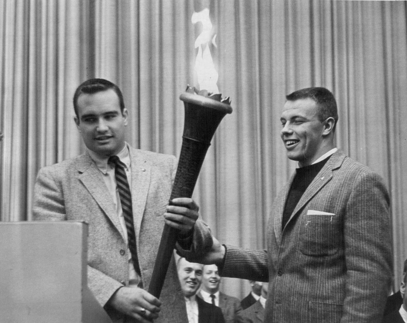 In December 1958, Mike Wright (left) received the torch symbolic of becoming the captain of the University of Minnesota football team for the year 1959 from Bud Svendsen,the 1958 Gopher football captain.