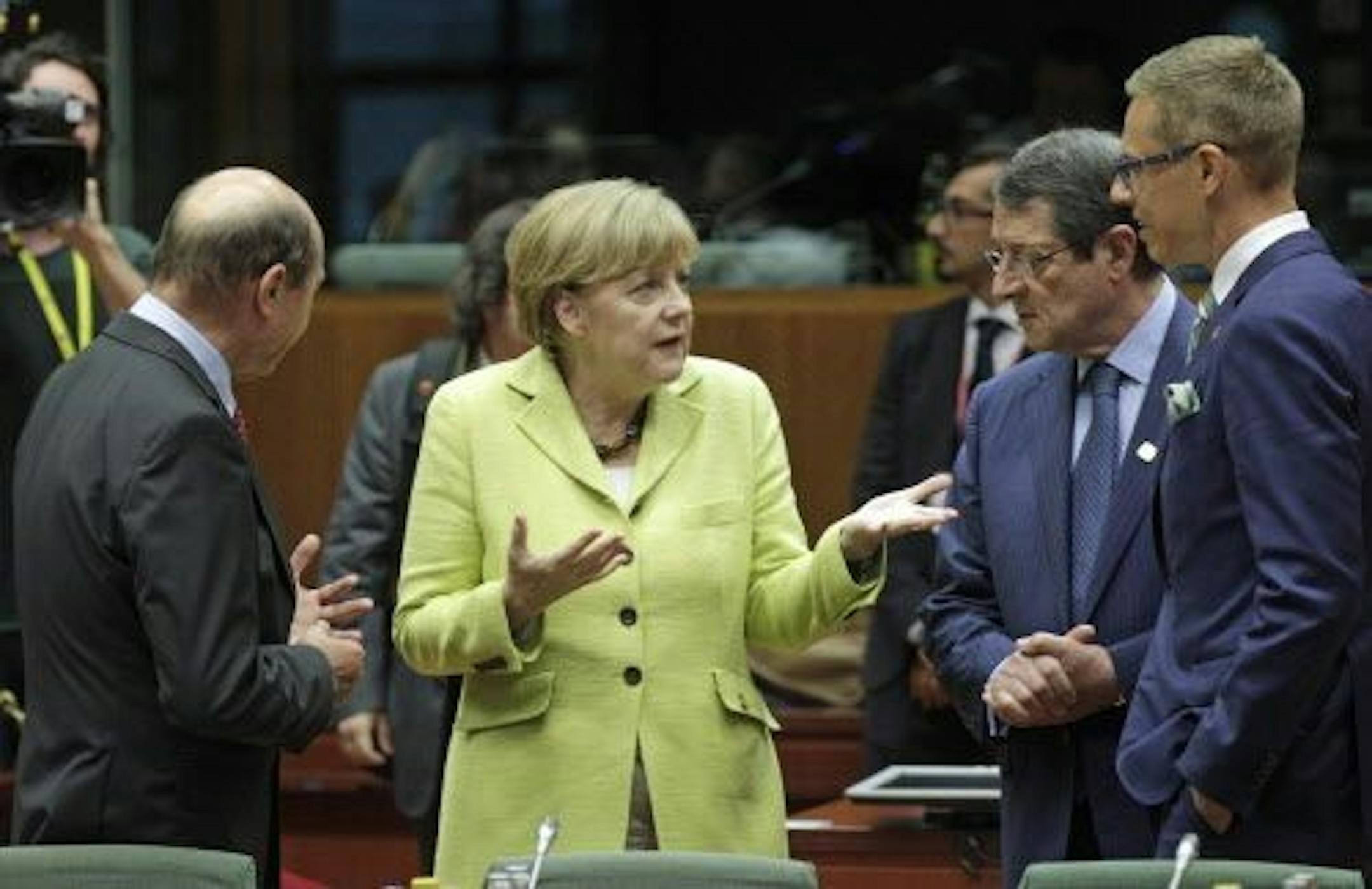German Chancellor Angela Merkel, center, talks with other leaders during an EU summit at the European Council building in Brussels, Wednesday, July 16, 2014.