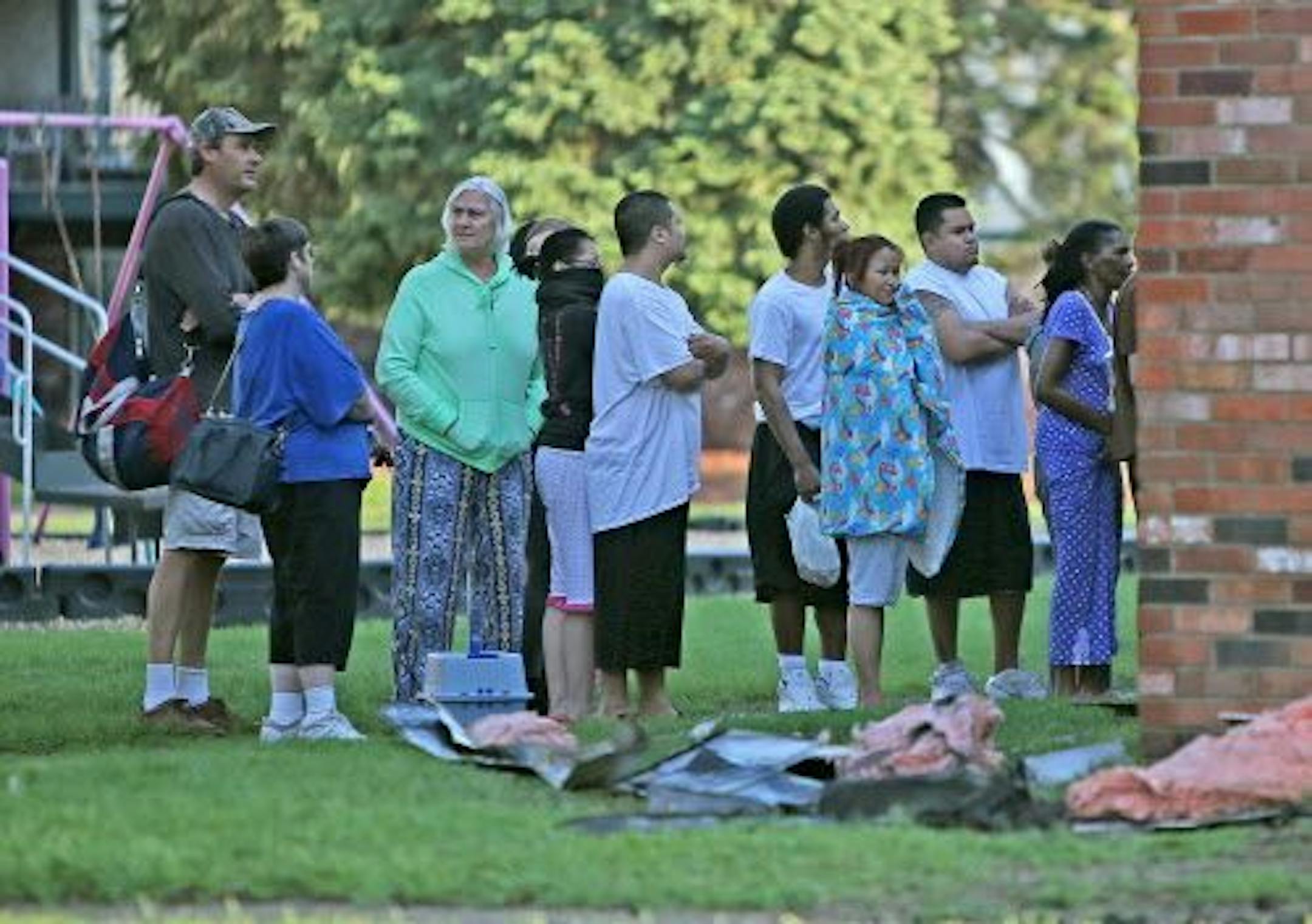 Residents of the Moonraker Apartments waited in line to retrieve items from their damaged apartments as a result of an early morning fire, Friday, May 30, 2014 in Brooklyn Park.