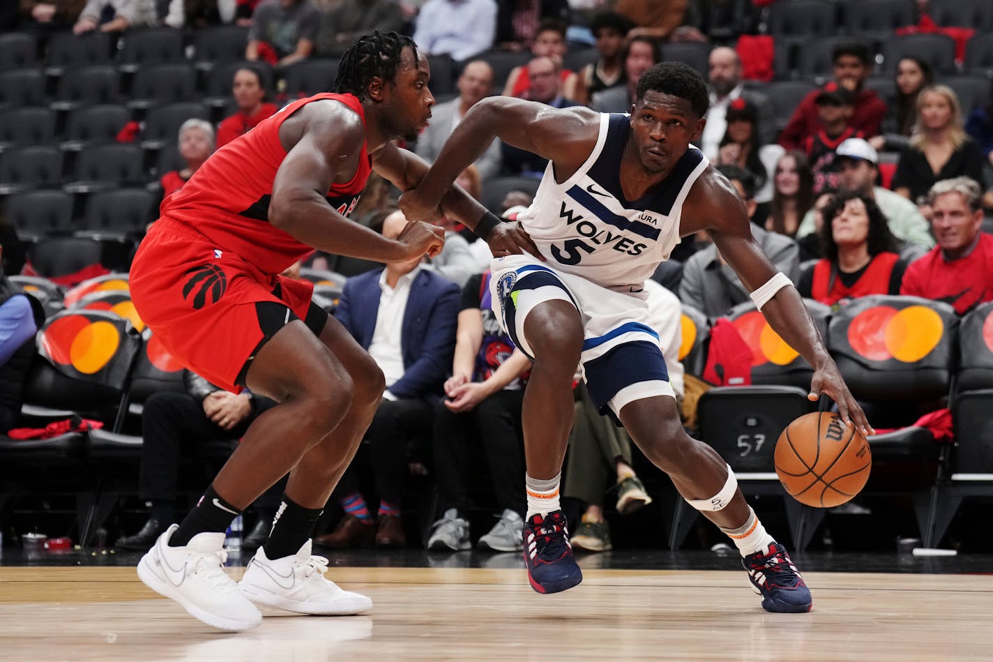 Minnesota Timberwolves' Anthony Edwards (5) protects the ball from Toronto Raptors' O.G. Anunoby (3) during the second half of an NBA basketball game Wednesday, Oct. 25, 2023, in Toronto. (Nathan Denette/The Canadian Press via AP)