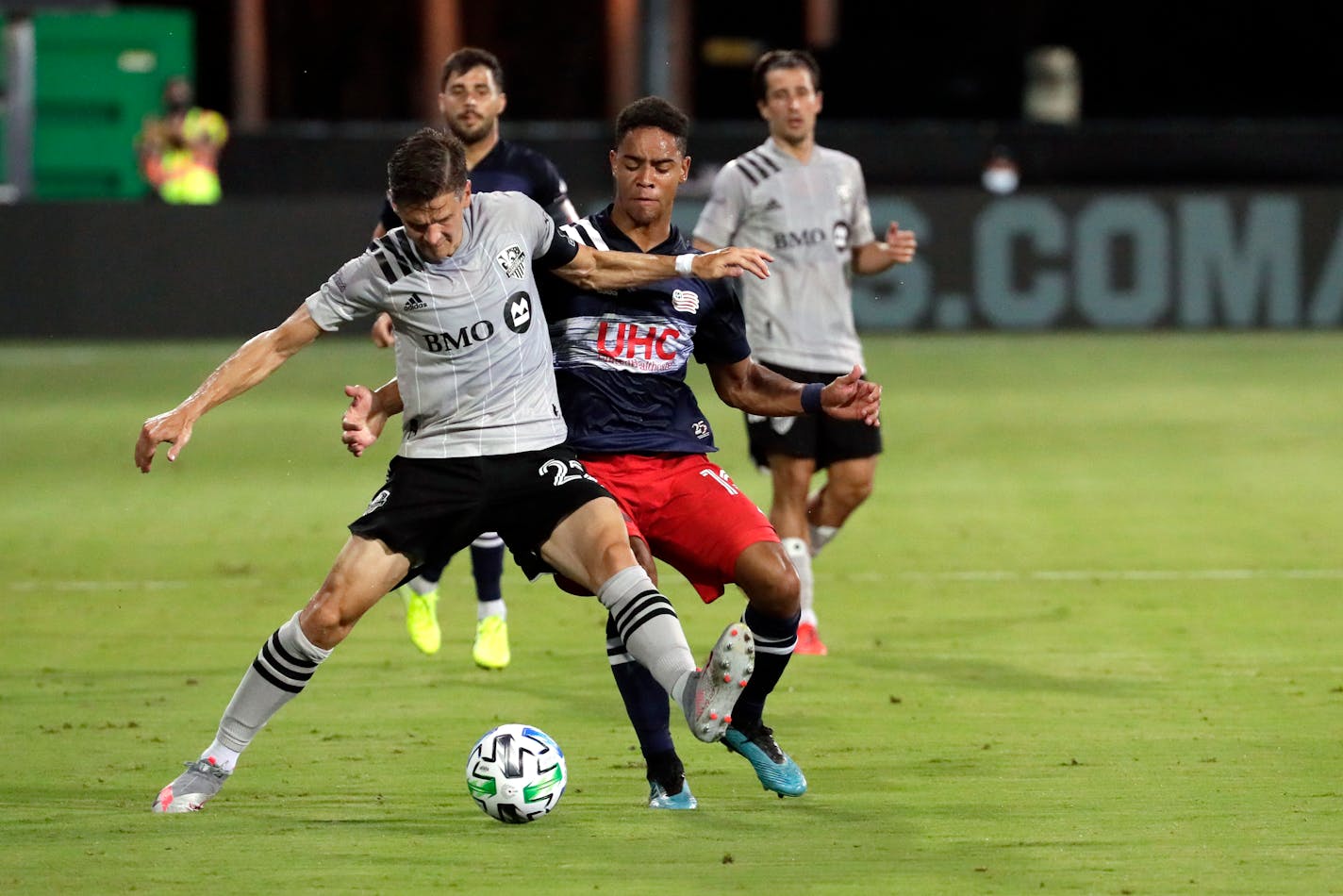 Montreal Impact's Jukka Raitala, front left, battles for position with New England Revolution's Brandon Bye during the first half of an MLS soccer match, Thursday, July 9, 2020, in Kissimmee, Fla. (AP Photo/John Raoux)