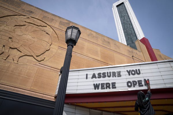 Dimitrius Stephens, an event production worker at the Uptown Theater, put up marquee letters before a media preview of the newly remodeled Uptown Thea