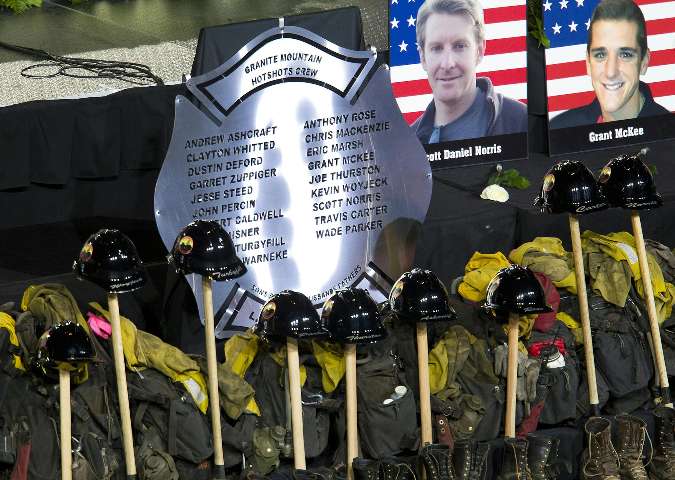 The names of the 19 fallen firefighters are displayed during a memorial service at Tim's Toyota Center in Prescott Valley, Ariz. on Tuesday, July 9, 2013. Prescott's Granite Mountain Hotshots were overrun by smoke and fire while battling a blaze on a ridge in Yarnell, about 80 miles northwest of Phoenix on June 30, 2013. (AP Photo/The Arizona Republic, Michael Chow, Pool) ORG XMIT: MIN2013070919355750