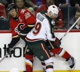 The Flames' Jarome Iginla, left, took a hit from the Wild's Stephane Veilleux in 2008