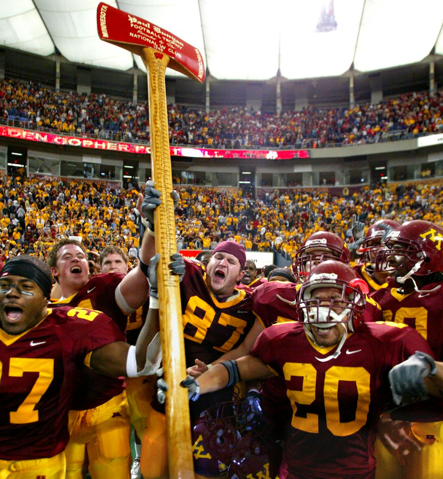 11/08/03 - Gopher football vs. Wisconsin - Minnesota wins 37-34. IN THIS PHOTO: Members of the Gopher football team lift high the Paul Bunyan axe that will be heading back to the Minnesota trophy case after they defeated Wisconsin on a last second field goal. ORG XMIT: MIN2013041713385505