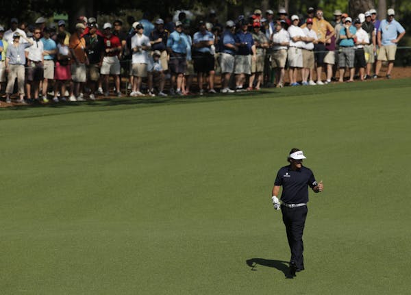 Phil Mickelson gives specters a thumbs up on the ninth fairway during a practice round for the Masters golf tournament Tuesday, April 9, 2013, in Augu