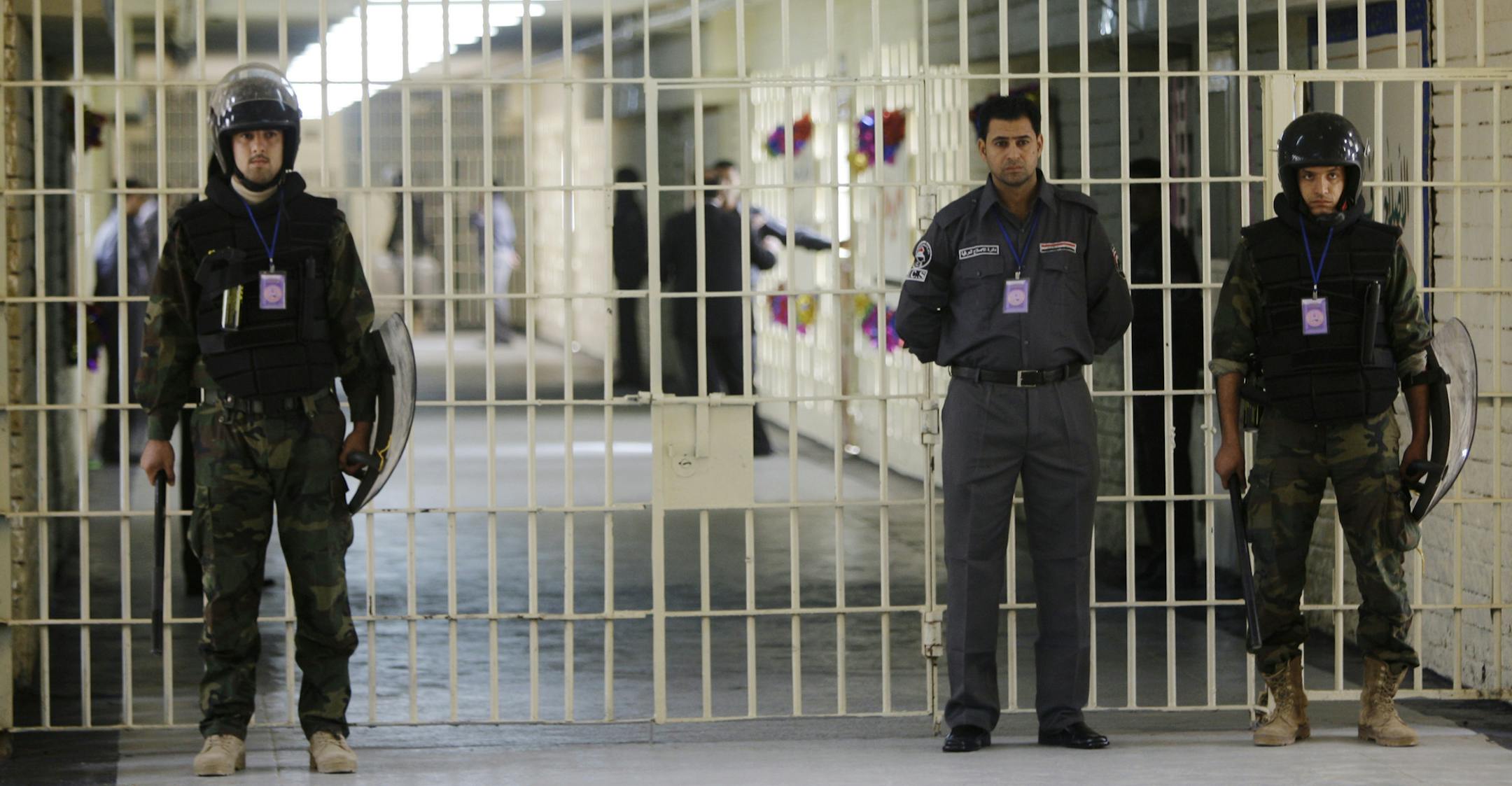 FILE - In this Feb. 21, 2009 file photo, guards stand at a cell block at Abu Ghraib prison on the outskirts of Baghdad, Iraq. Al-Qaida's branch in Iraq claimed responsibility for audacious raids on two high-security prisons on the outskirts of Baghdad last mont that killed dozens and set free hundreds of inmates, including some of its followers.