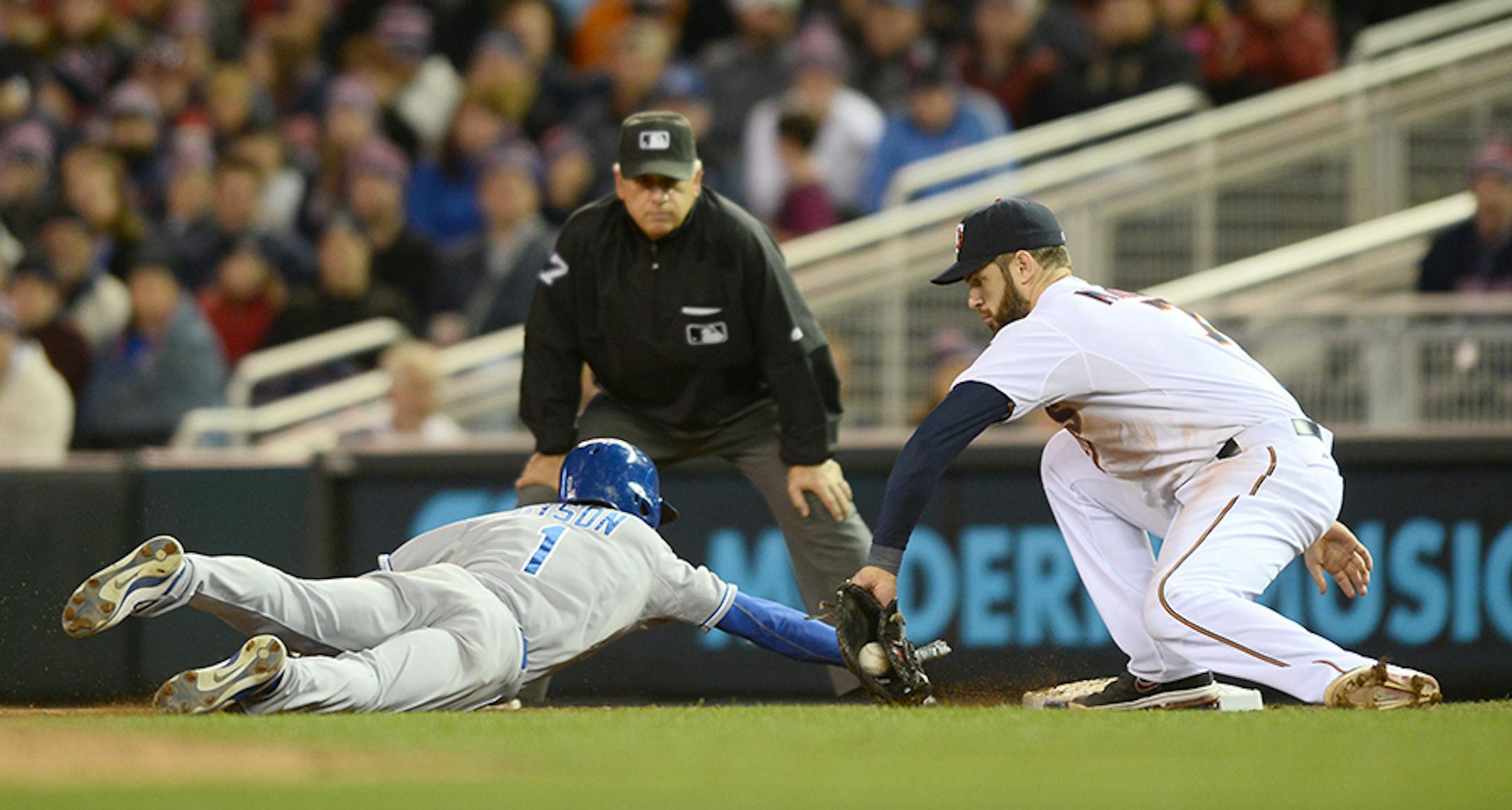 Minnesota Twins first baseman Joe Mauer (7) nearly tagged out Kansas City Royals center fielder Jarrod Dyson (1) as he slid safely back to first in the ninth inning.