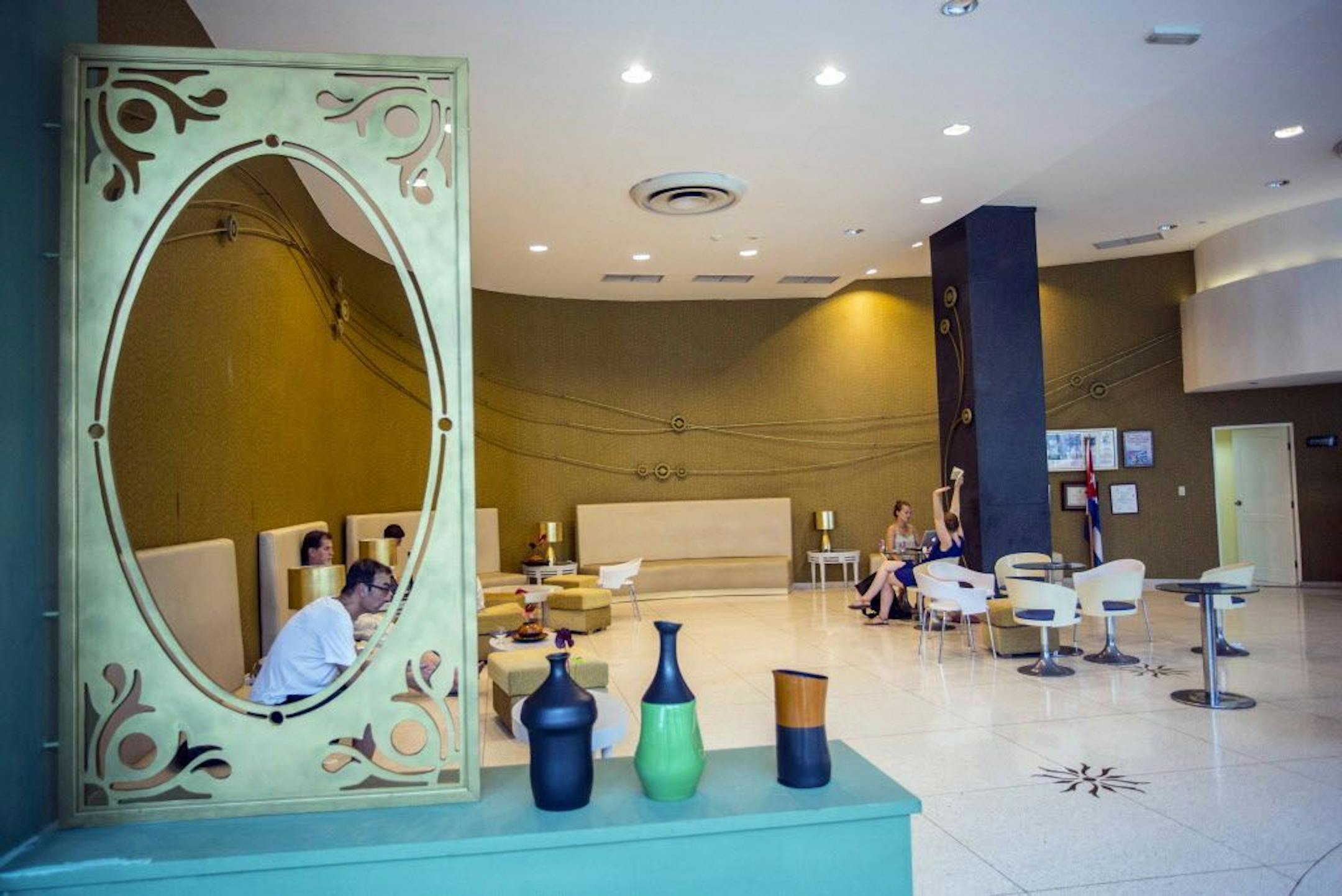 In this Sept. 12, 2017, photo, people sit in the lobby of the Hotel Capri in Havana, Cuba. New details about a string of mysterious �health attacks� on U.S. diplomats in Cuba indicate the incidents were narrowly confined within specific rooms or parts of rooms. Aside from their homes, officials said Americans were attacked in at least one hotel, the recently renovated Hotel Capri, steps from the Malecon, Havana�s iconic, waterside promenade.