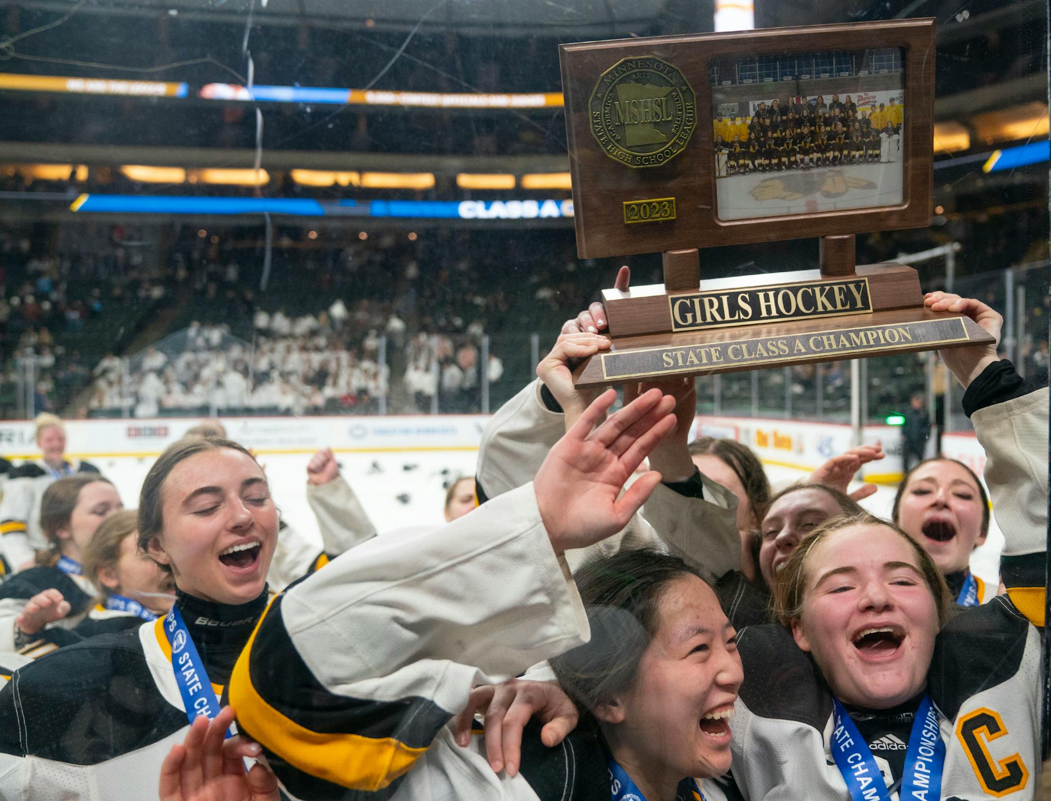 Warroad players celebrate after defeating Orono 3-1 to win the Class 1A girl's hockey championship.