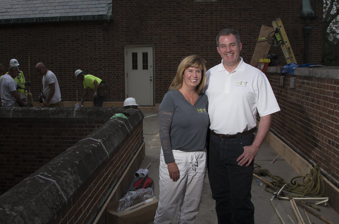 Kevin Krolczyk and his wife, Michele Krolczyk, on the roof of the Annunciation church-and-school complex in south Minneapolis. Kevin Crolczyk quit his computer software job in 1993 to buy the former Dalbec Roofing from Michelle's parents. They renamed it Mint Roofing in 2012. Photo by CARLOS GONZALEZ cgonzalez@startribune.com - June 8, 2015, Minneapolis, MN,