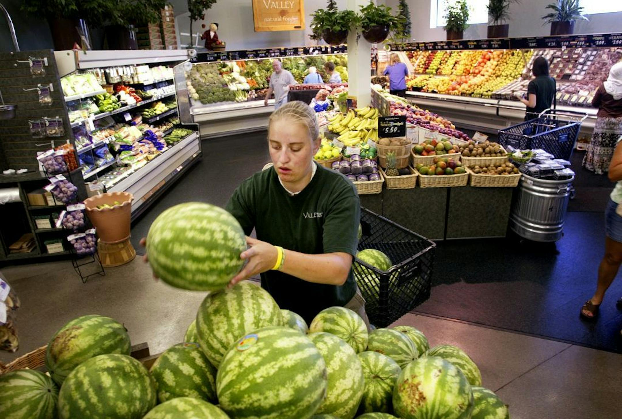 A Valley Natural Foods worker stocked watermelons as customers shop at the Burnsville co-op Thursday, Aug. 3, 2006.