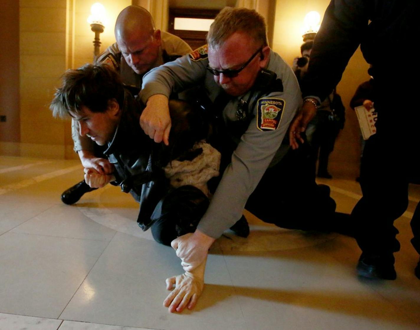 Capitol police officers take an anti-Trump protestor to the crowd before taking him into custody during a clash between pro and anti-Trump supporters at a national March4Trump at the State Capitol Saturday, March 4, 2017, in St. Paul, MN.