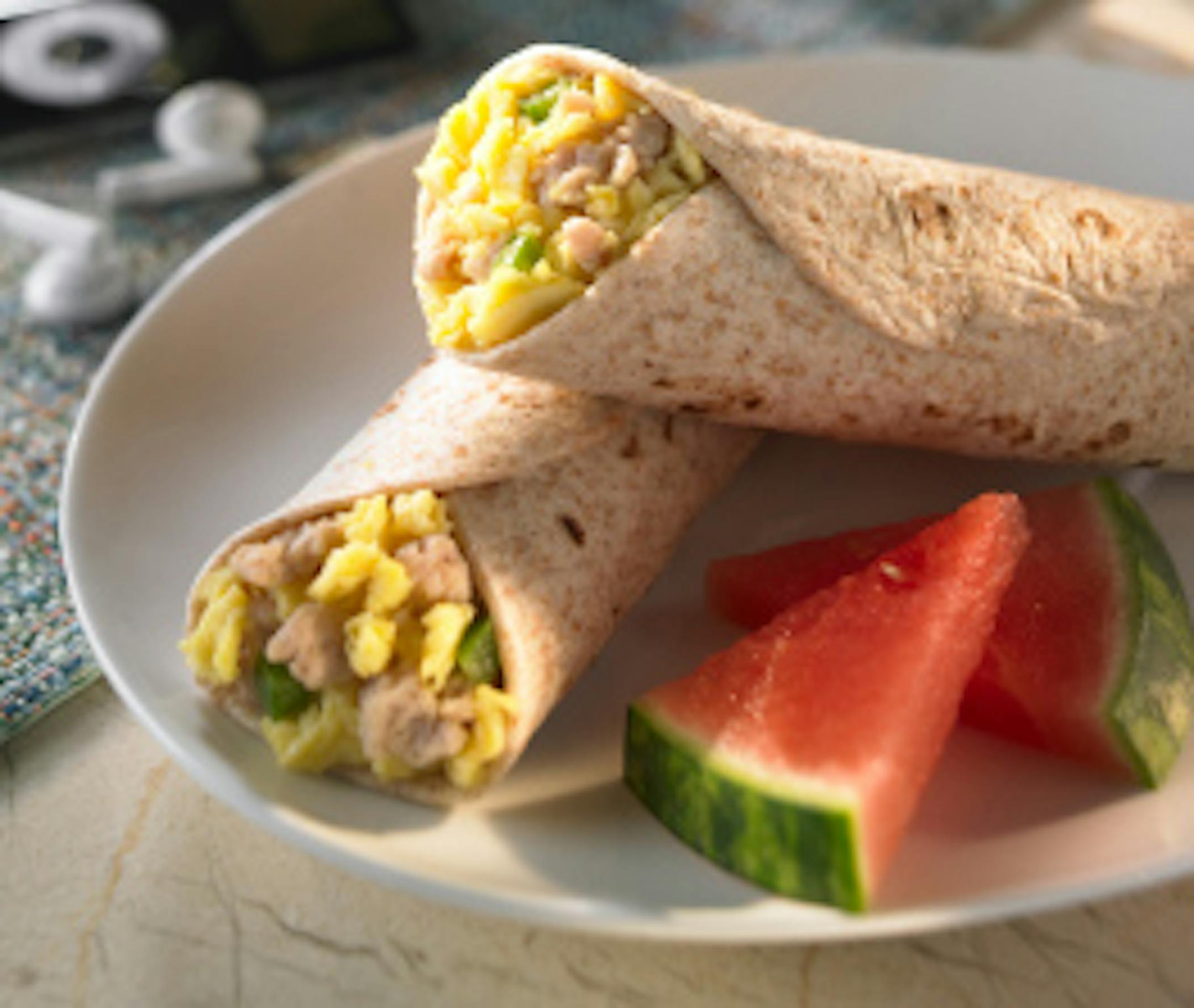 Plate of breakfast buritos with a slice of watermelon