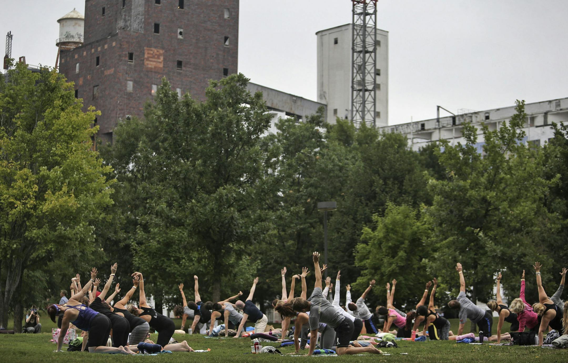 Yoga Rocks the Park transformed Father Hennepin Bluffs Park in a slowly moving sculpture of humans doing yoga Saturday, Aug. 23, 2014, in Minneapolis, MN. Here, about 75 participants practiced yin yoga, a slower form of yoga with poses held for longer periods of time.] (DAVID JOLES/STARTRIBUNE) djoles@startribune Yoga Rocks the Park, a summer-long series, with Yoga in an outdoor setting with live music, transformed Father Hennepin Bluffs Park in a slowly moving sculpture of humans doing yoga Sat