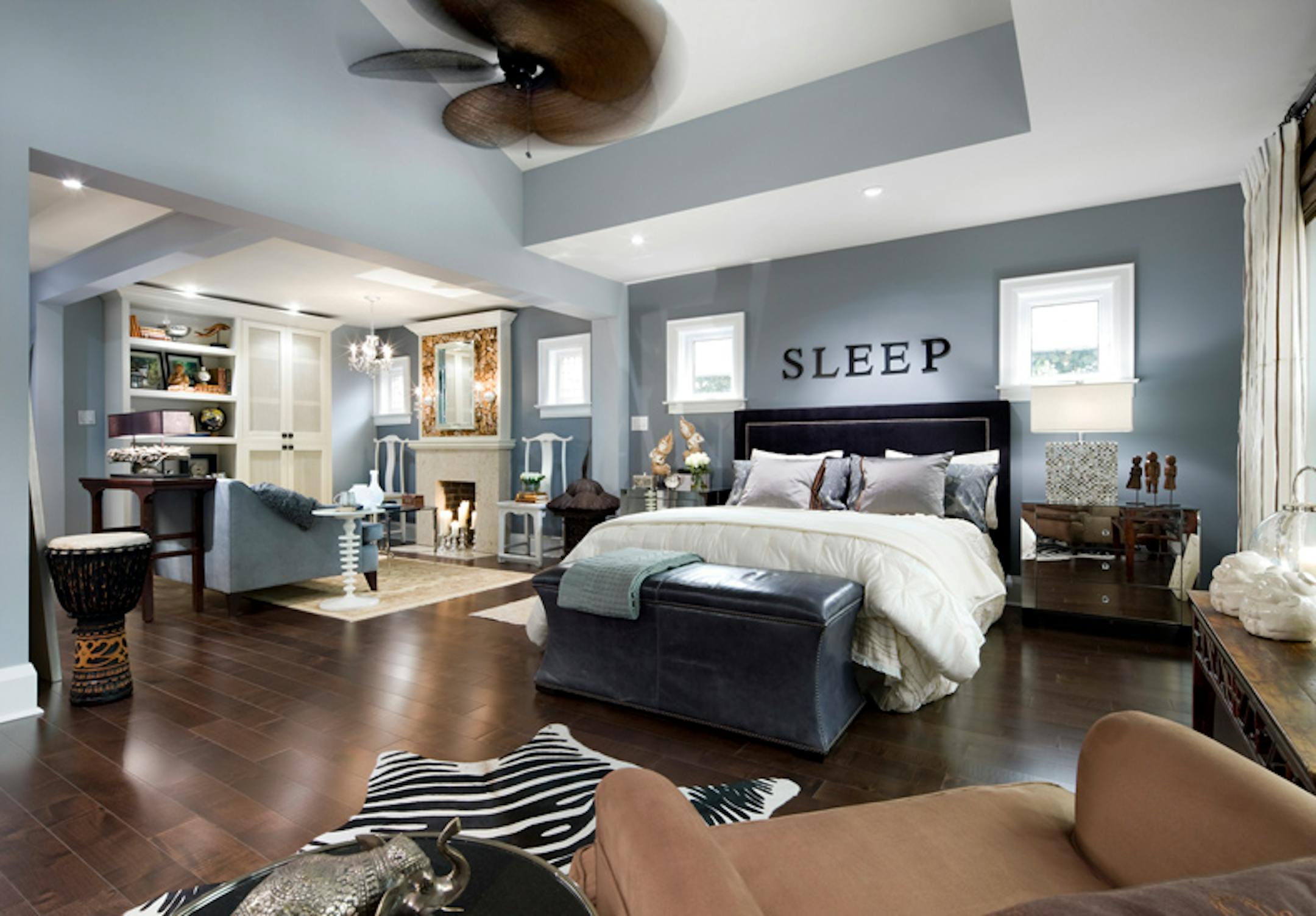 After: The walls are painted a deep silvery blue, a color echoed in the love seat. Linen drapery panels with a blue and brown stripe mesh with the blue walls and dark chocolate-colored floor.