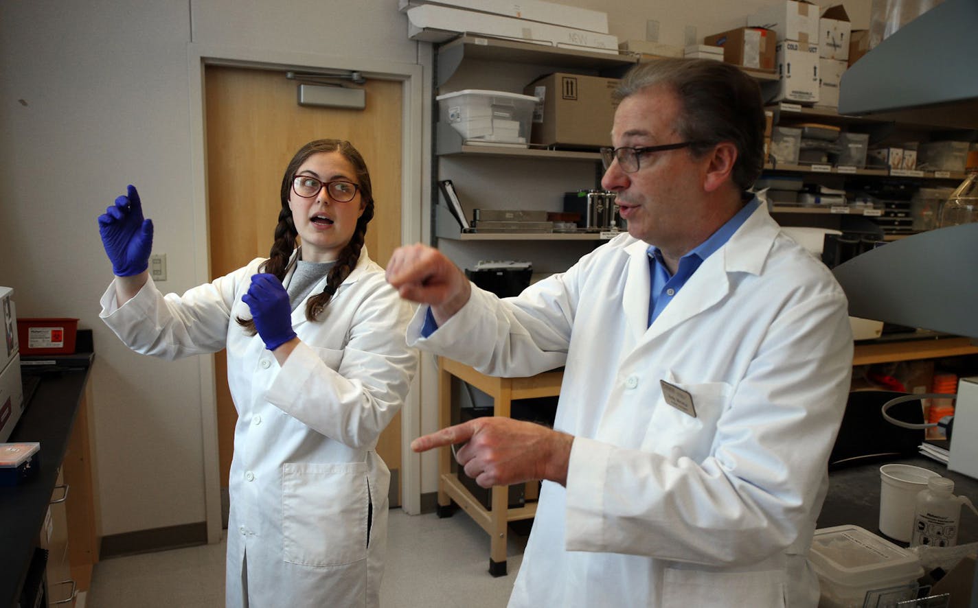 Purdue University biochemistry graduate student Emma Lendy talks with Andy Mesecar, one of the leading scientists identifying protein targets for potential COVID-19 drug therapies, on April 30, 2020 on campus at Purdue in West Lafayette, Ind. (Terrence Antonio James/Chicago Tribune/TNS)