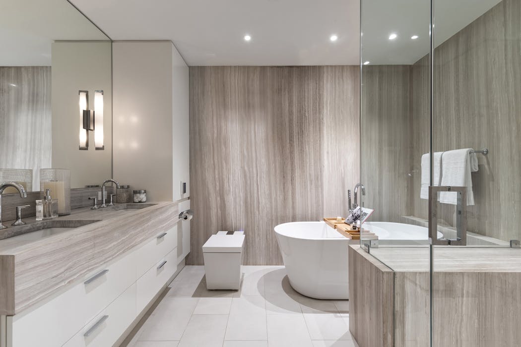 A bathroom wrapped in stone, creates a sense of luxury in this modern, urban bathroom.