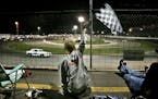 Jared Moderie, 13, of Eagan waves a checkered flag he purchased during a cruiser race during the Eve of Destruction racing event at the Elko Speedway,