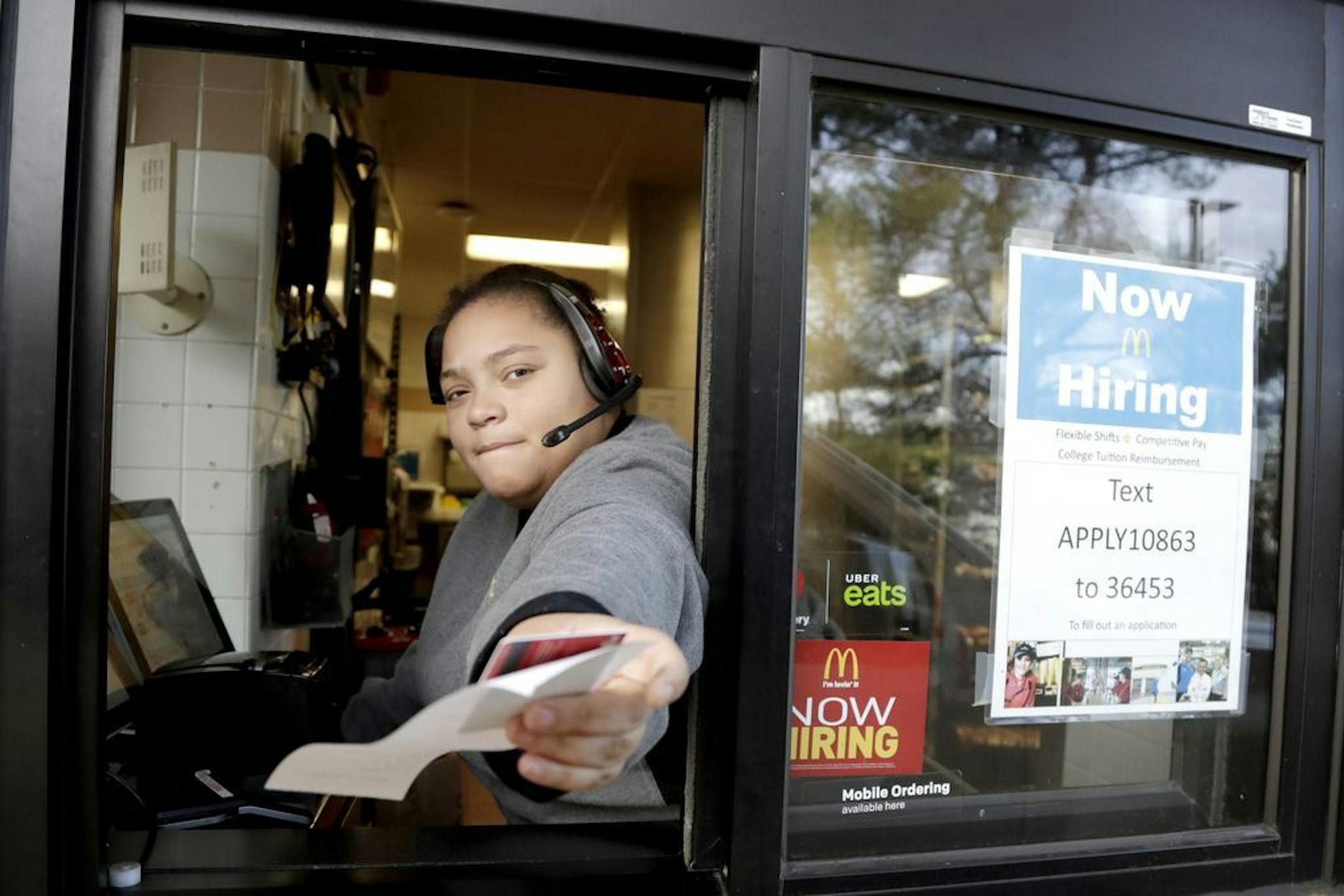 A cashier returns a credit card and a receipt at a McDonald's window, where signage for job openings are displayed, Thursday, Jan. 3, 2019, in Atlantic Highlands, N.J.