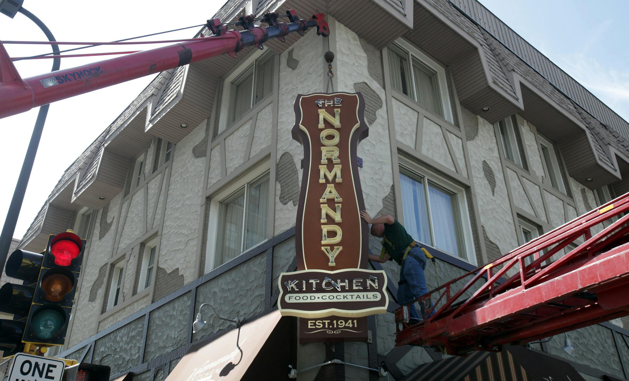 KYNDELL HARKNESS ¥ kharkness@startribune.com 7/31/09 Normandy Inn gets faclift[Chris Woodward, of Nordquist, worked on attaching the new sign for the Normandy Kitchen as a part of the renovations for the Normandy Inn hotel.